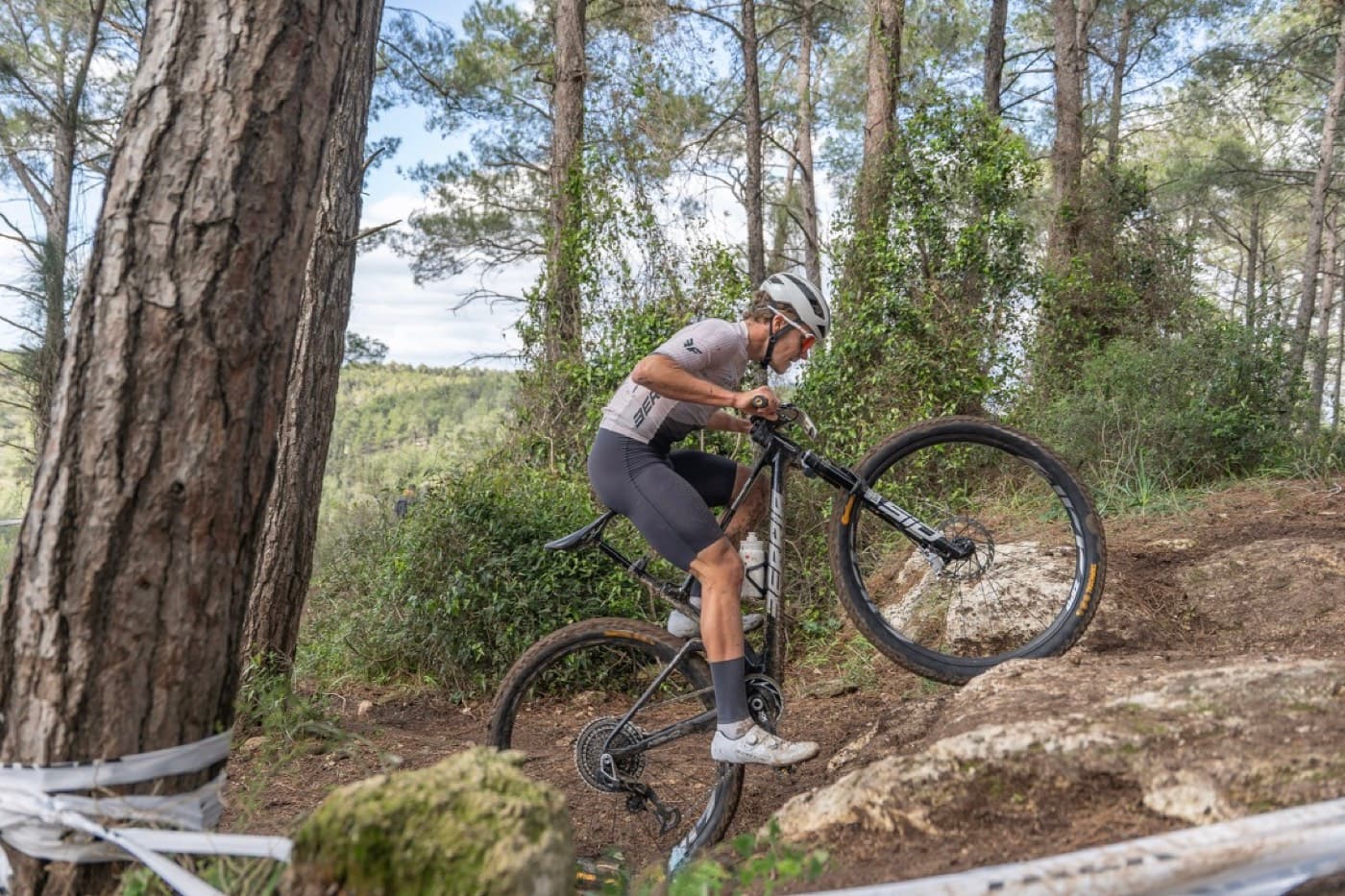 Tomer Caspi riding a technical rock feature on a forest trail